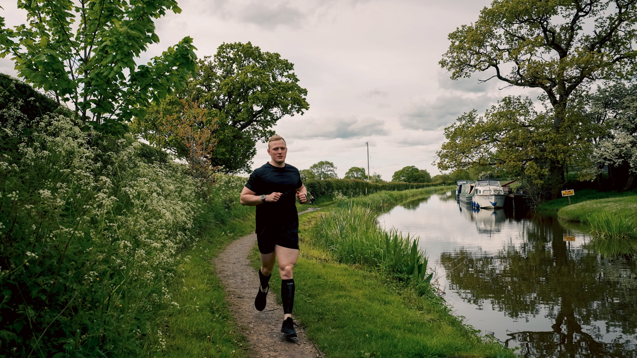 Man running next to canal in CRX Compression Wear